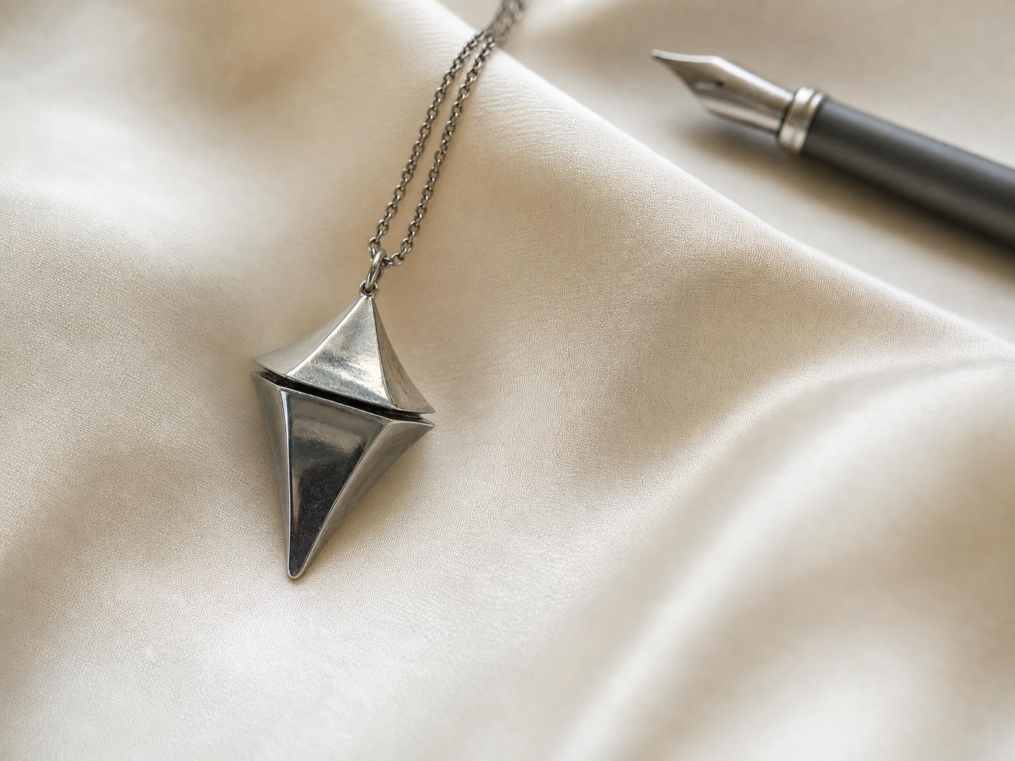 Concept macro study of the geometric Glimmer pendant on ivory silk